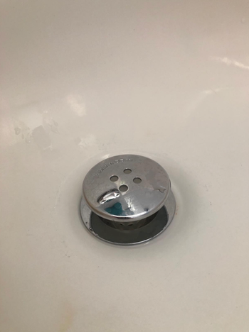 A TubShroom sitting in a drain.