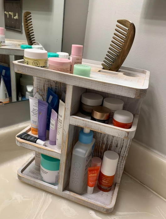 A bathroom countertop organizer holding an array of skincare and haircare products, with a comb placed neatly on top