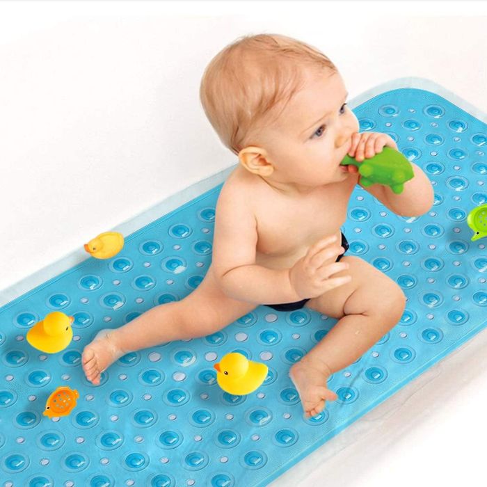 A lifestyle photo showing a baby sitting on the blue bath mat.