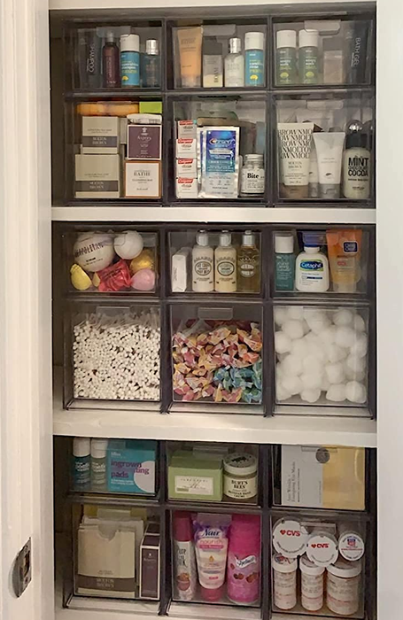 A reviewer's closet filled with stackable drawers holding a mix of cosmetics, medications, and other bathroom essentials