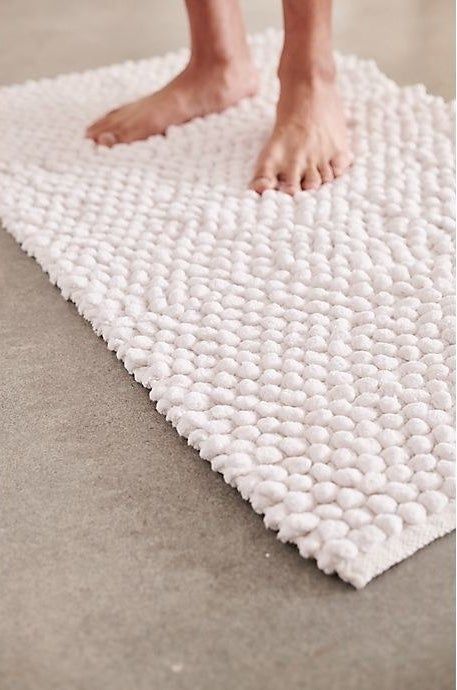 The white pebble-textured bath mat