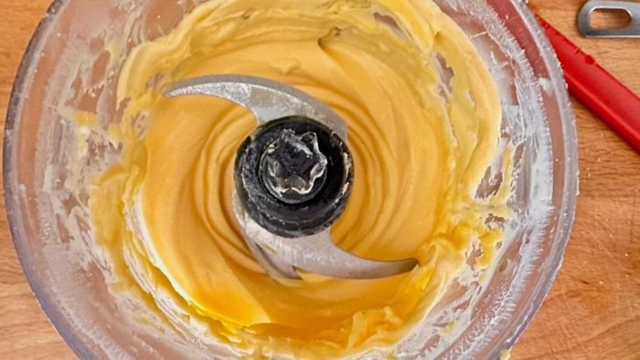 Hollandaise sauce being processed in a small food processor.