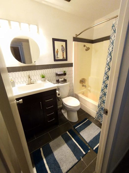 A photo showing two blue striped bath mats arranged in a bathroom setting.