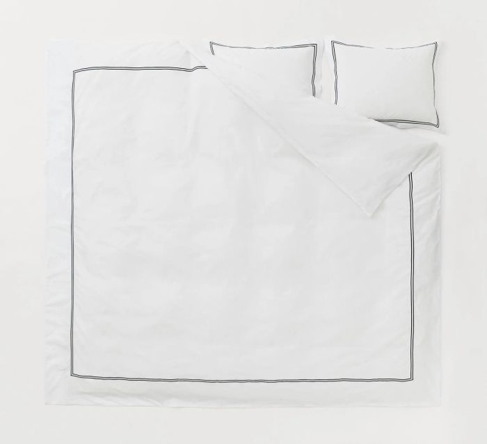 White duvet cover with a black border and matching pillowcases, set against a white background.