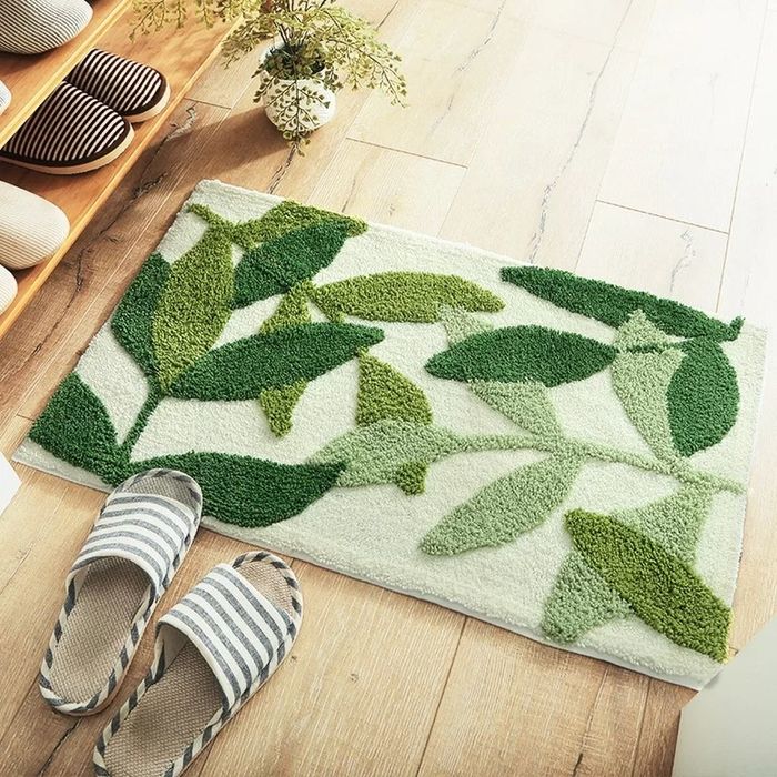 A bathroom rug with a leaf pattern, rectangular in shape.