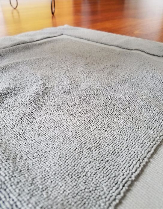 Close-up reviewer photo showcasing the gray bath mat