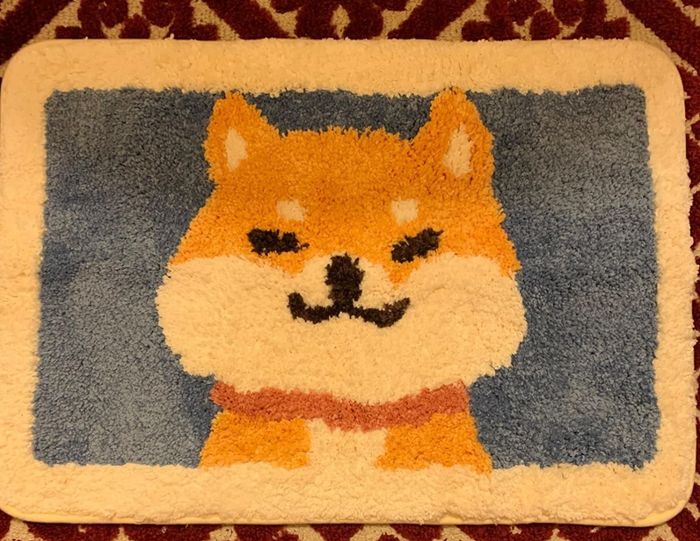 A reviewer image featuring a charming corgi bath mat.