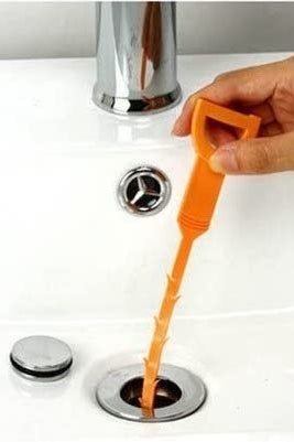 An orange drain snake being inserted into the drain