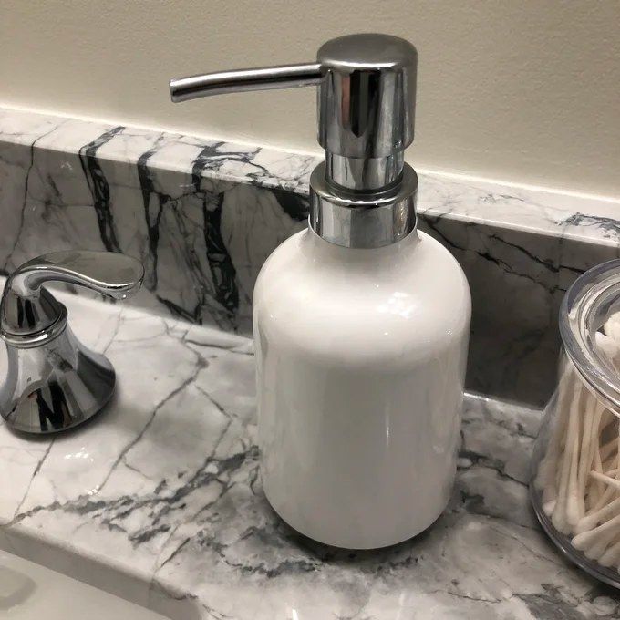 A white soap dispenser placed neatly on a countertop