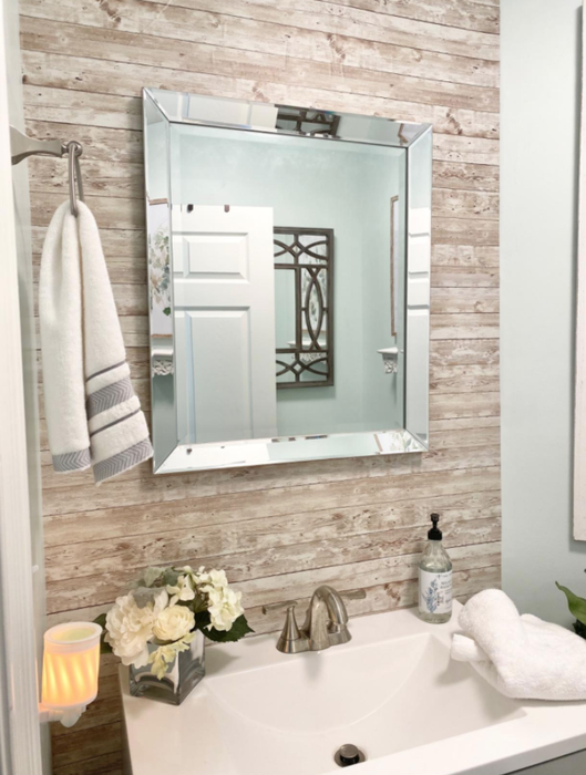A bathroom featuring the wallpaper used as an accent behind the sink mirror.