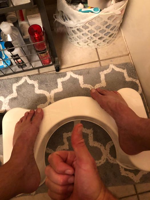 A reviewer sitting with their feet on the stool, giving a thumbs up.