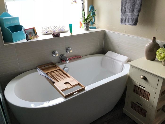 A white pillow designed to attach to the side of your bathtub, bringing extra comfort to your bath experience.
