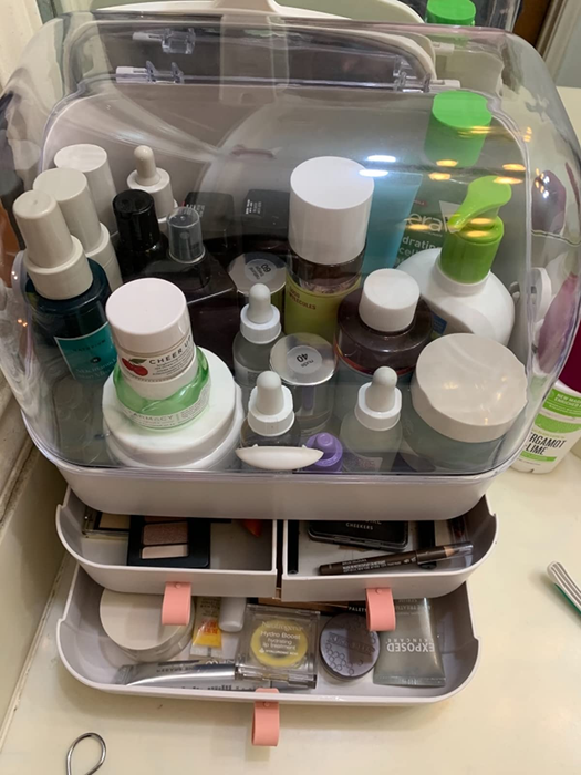 A reviewer’s photo showing the organizer filled with cosmetics, with the bottom four drawers opened.