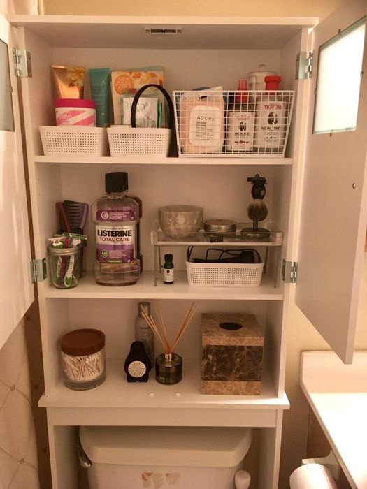 A different reviewer's image showcasing the cabinet's full potential, with shelves perfectly organized and stocked with multiple baskets of toiletries.