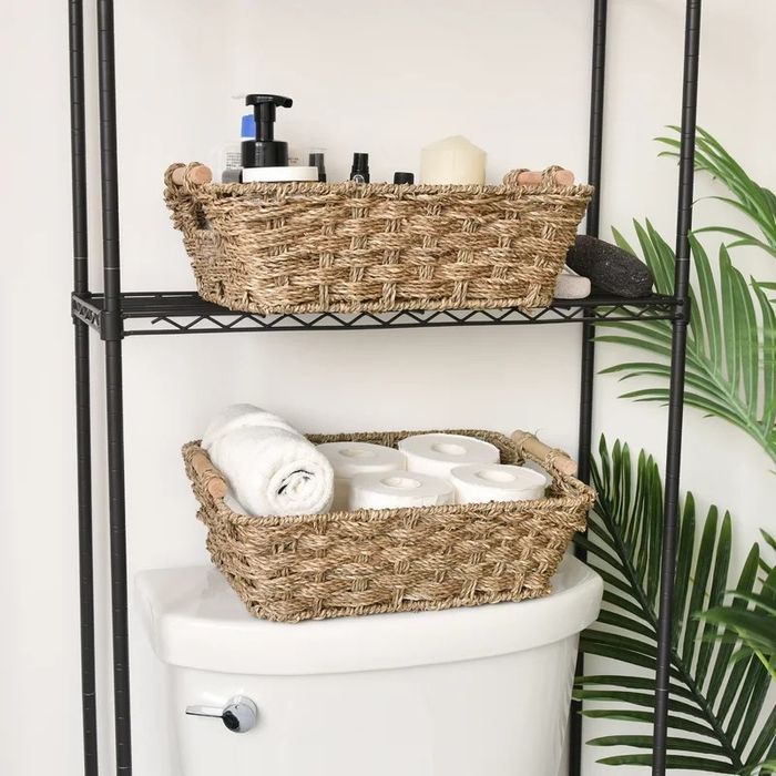 Two storage baskets with handles, filled with towels and a variety of other bathroom essentials