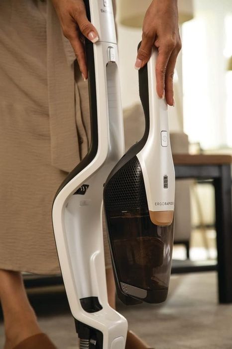 A person using a detachable cordless vacuum cleaner in their home for versatile cleaning