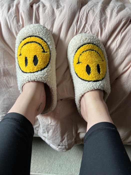 Mytour editor rocking white fuzzy slippers adorned with cheerful yellow smiley faces