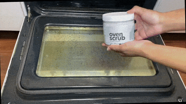 Person using the oven scrub cleaner to eliminate stubborn stains from their oven.