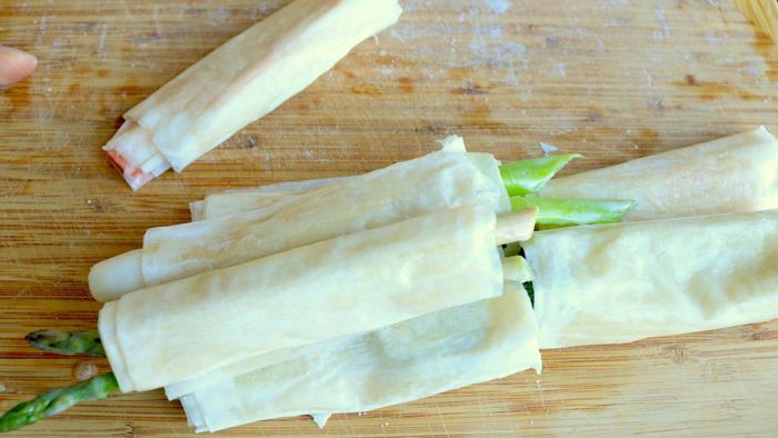 Phyllo-wrapped vegetables are neatly stacked on a cutting board.