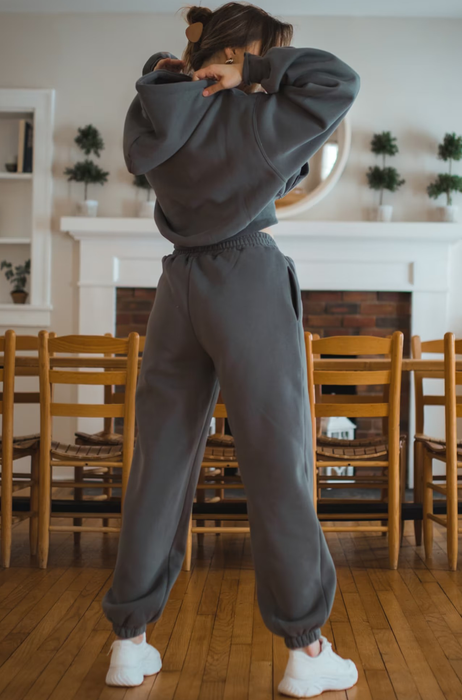 Back view of a model wearing the gray sweat set paired with white sneakers