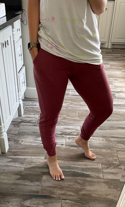 A reviewer wearing burgundy stretchy joggers