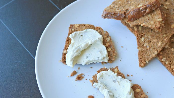Crackers made with sunflower seeds and topped with a creamy cheese spread
