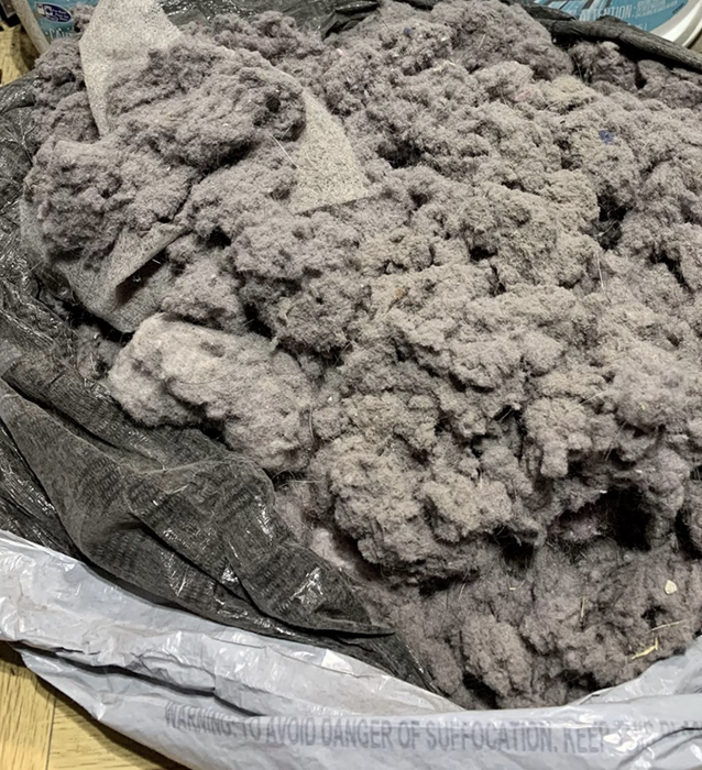 Another reviewer image showing a garbage bag filled three-quarters full with lint