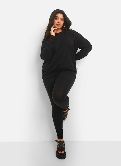 a model in black leggings and a black sweatshirt