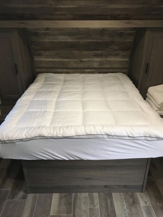 A mattress pad placed on top of the topper