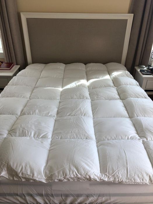A quilted mattress topper placed on a bed