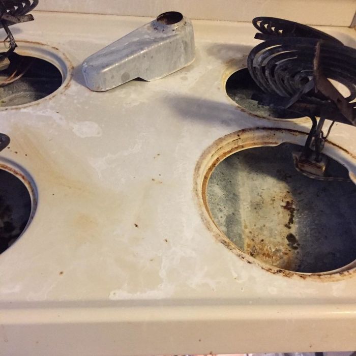 Reviewer photo showing their stovetop covered in burnt food, grease, and grime, making it look incredibly dirty.