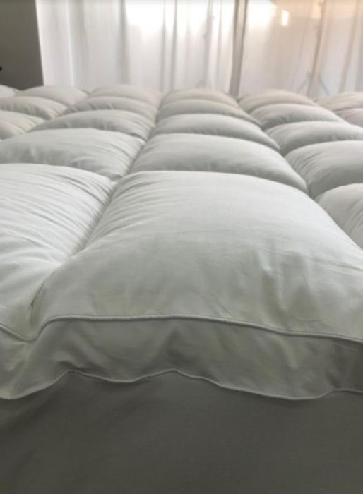 A side view of the mattress topper, showing its thickness