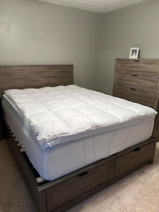 A pillow topper placed on top of the same mattress pad