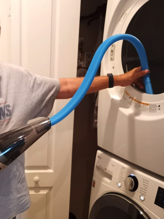 A reviewer using the vacuum hose and inserting it into the dryer vent