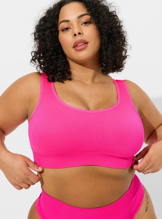 A model showcasing a pink ribbed bralette.