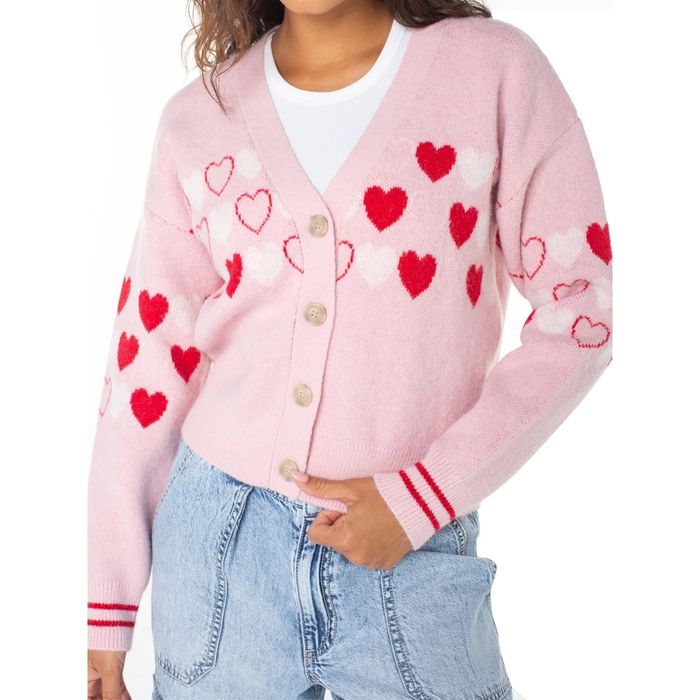 A model wearing a playful pink and red heart-patterned cardigan, exuding warmth and charm.