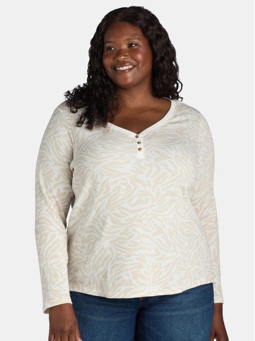 Woman smiling while wearing a patterned long-sleeve Henley shirt and jeans