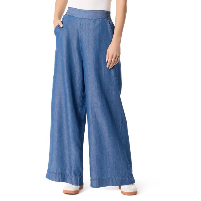 Wide-leg denim trousers paired with a white top and matching white shoes, featured in a shopping article