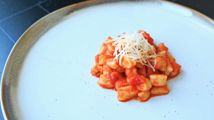 A plate of gnocchetti served with tomato sauce.