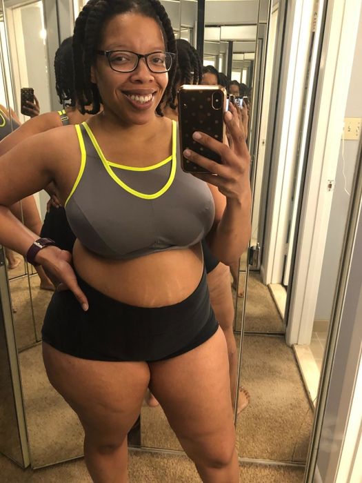 A reviewer wearing a gray and neon yellow sports bra paired with comfy shorts.