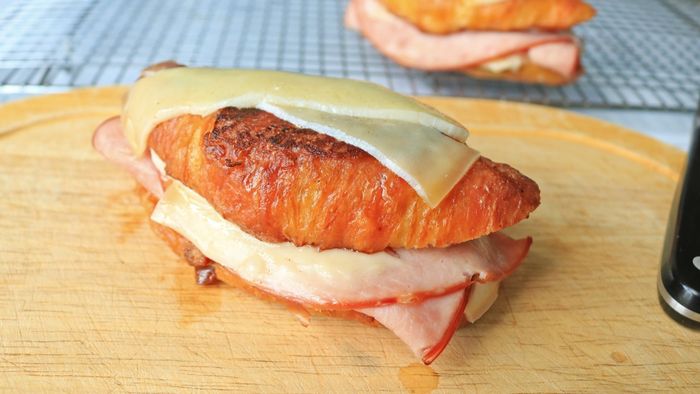 A Croque Monsieur rests on a cutting board, awaiting its moment to shine.