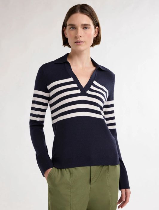 A person is seen wearing a striped V-neck sweater paired with green pants, creating a laid-back yet stylish outfit suitable for various casual occasions.