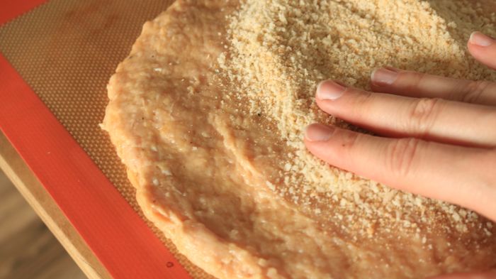 Pressing the breadcrumbs onto the crust
