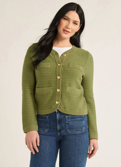 Person modeling a textured green button-up cardigan with pockets over a white shirt and blue jeans