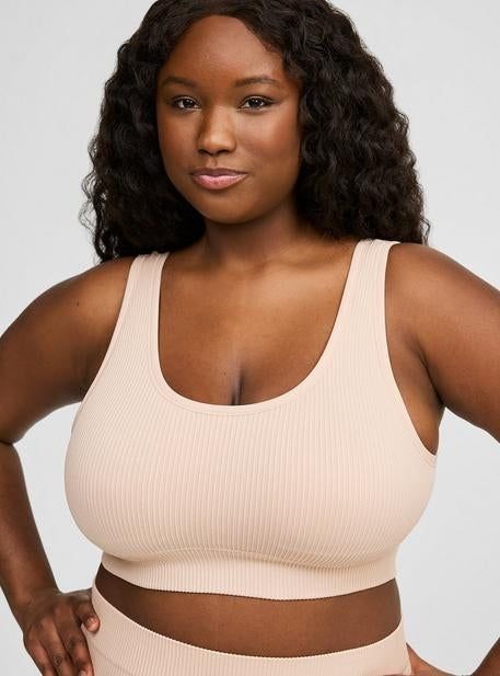 A person wearing a ribbed, sleeveless crop top, ideal for both activewear and casual looks.
