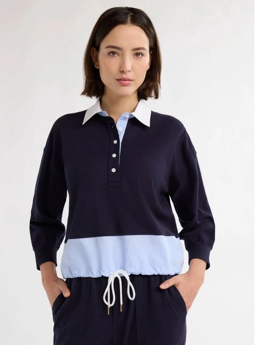Person wearing a casual polo with a buttoned collar and a drawstring waist, shown in a shopping feature