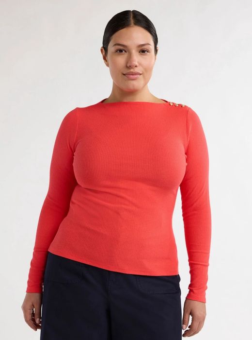 A model showcasing a red top paired with black pants, creating a chic and classic look.