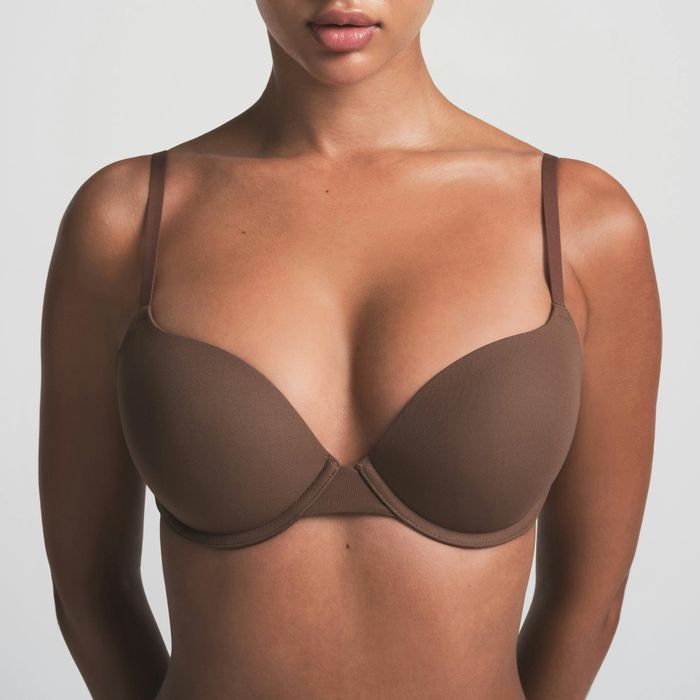 A person wearing a seamless, supportive bra, featured in a shopping guide on comfortable lingerie options.