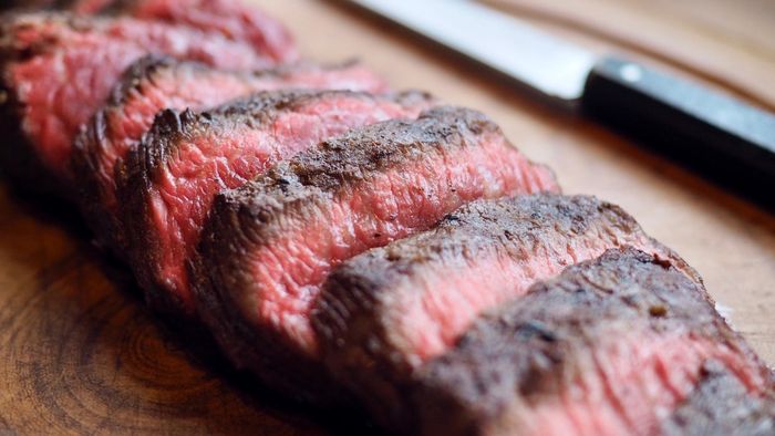 A sliced steak placed on a cutting board