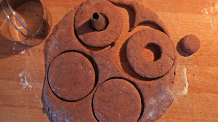 Chocolate dough being sliced on a cutting board.